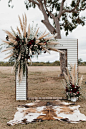 iron wedding arch with plumes of pampas grass and burgundy flowers