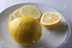 大理石背景上的极简风格柠檬片，白色盘子上的柠檬，健康食品，素食主义者，波普艺术，白色背景上的黄色柠檬