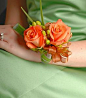 wrist corsage of beautiful orange roses and hypericum