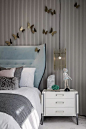 Sculpture above bed, modern headboard and striped wallpaper