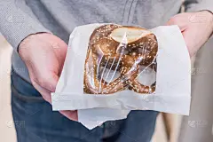 圣诞节在糕点店买椒盐卷饼的男人