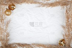 干花框架，白色皱巴巴的背景上点缀着金色的圣诞装饰。用于网页设计屏保的纹理。本空间