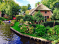 荷兰的羊角村，沿小河而建的房子，绿绿草坪上点缀着缤纷花朵。 ​​​​