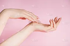 粉色背景上美丽的女性手。温泉和身体护理的概念。广告形象.