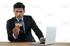 使用笔记本电脑时持有信用卡的商人