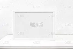 水平白色框架模型在白色的桌子上对着白色的墙壁。空海报框架模型设计。本空间