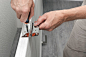 Man installs the door hinge on the door with a screwdriver. Tightening the screws. Renovation in the house.