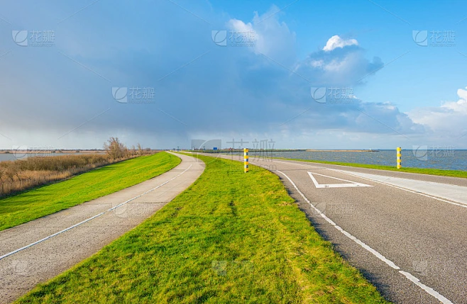 在冬天沿着湖泊越过堤坝的道路