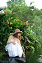 Woman Wearing White Dress Squatting Near Body of Water Near Plants