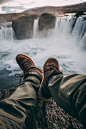 Person Sitting on Rock Near Waterfalls