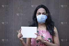 戴着医用口罩的妇女，拿着空白的宣传牌