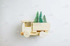 木制玩具车与圣诞树在白色的背景。节日卡片。副本的空间。平铺，俯视图圣诞或新年最小概念。