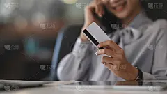 近距离观看年轻女子持有信用卡购物和支付。