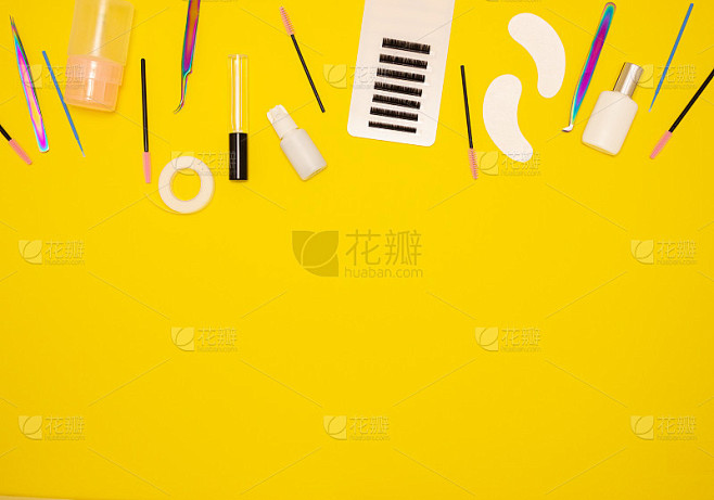 工具的睫毛延伸在一个黄色的背景，俯视图。...