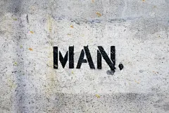 在水泥墙上喷涂“MAN”字样。