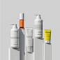 This may contain: several different types of skin care products on white pedestals with yellow and orange labels