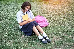 学生们穿着校服在学校的花园里看书。