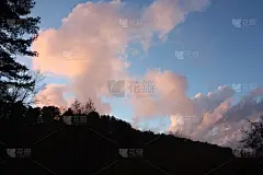 傍晚到达。夕阳将湛蓝的天空和粉红色和橙红色的云彩染成了色彩。群山变得越来越黑。