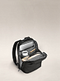 Inside view of a small backpack in black with internal pockets organized with various accessories.