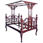 A richly toned mahogany bed with tester canopy from northern India, circa 1930. The intricately carved frame has mirrors reverse etched with musical instruments on the outside of the head- and footboards and upholstery on the inside. The frame comes with