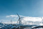 wind turbines on snowy mountain under clear blue sky during daytime