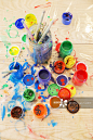 Jars of paint and paintbrushes on wooden table