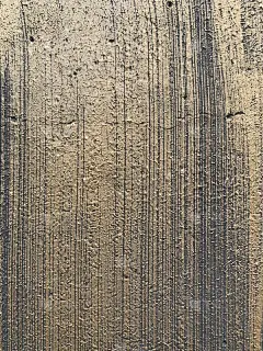 一幅黑色和金色的墙壁上有笔触条纹的照片。粗糙的垃圾纹理，背景或背景