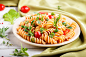 Fusilli pasta with tomato sauce cherry tomatoes lettuce and herbs on a white wooden background Premium Photo