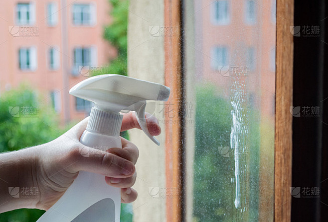 Cleaning window pane with spray detergent. Outside