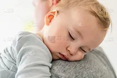 可爱可爱的金发白种人小孩的特写肖像睡在父亲的肩膀室内。甜美的小孩感觉安全的爸爸的手。责任和照顾孩子。
