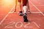 新年还是开始直概念。近距离观看刻有2021年铭文的运动员跑步成功和新成就的鞋子。在日落时分。