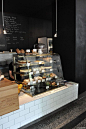 this i like...a lower wall at one end of the bar for the bakery case / cases, then the bar runs along the entire length. and chalkboard paint on the walls, you could do a little area for kids to do chalk near the bakery case.: