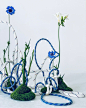 This may contain: two blue and white sculptures made out of rope with flowers in the middle on top of them