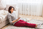 Young woman relaxing on floor at home reading book