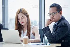 快乐的年轻商人和女商人团队一起工作与笔记本电脑在办公桌上讨论信息在办公室。老板和秘书在Windows