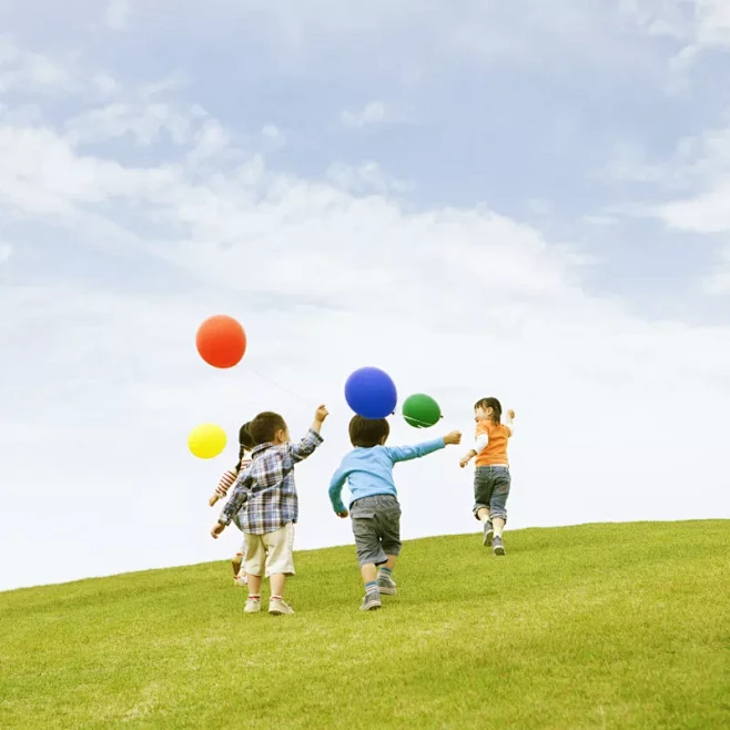 孩子们拿着气球在草地上奔跑图片下载