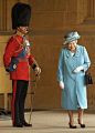 The Queen laughing as she passes her husband, the Duke of Edinburgh in uniform. This is adorable.