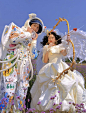 This may contain: two people dressed up in costumes standing next to each other holding arrows and an umbrella