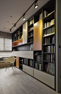 书架是盛大开放空间中真正的核心物品，从地板到天花板都容纳着不对称的开放式架子和封闭式橱柜。 橙色和米色的光滑面板为经典设计增添了至关重要的现代气息。
