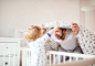 Father with a toddler boy having fun in bedroom at home at bedtime.