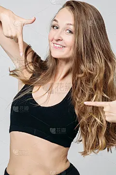 正能量运动女孩用手指指着黑色的顶部。