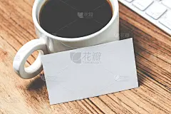 木桌上放着空白的名片和一杯咖啡。企业文具品牌模拟。