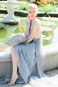 美丽的新娘肖像在美丽的蓝色婚纱在自然的背景。