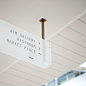  Overhead directional signage in frosted glass, with copper coloured metal frames.  