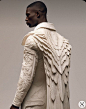 This may contain: a man with wings on his back is wearing white clothing and holding a black bag