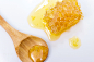 Piece of honeycomb with wooden spoon