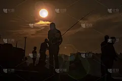 夕阳下抱鱼的剪影。