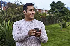 傍晚的灯光下，一个男人戴着新的无线耳机站在城市的郊区