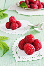 raspberry valentine : ripe juicy raspberries on napkins in the shape of hearts on a colored wooden background. from his garden berries. selective focus. valentine's day concept