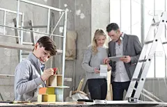 快乐的孩子们用建筑模型盖房子。他的家人通过上网浏览数字平板电脑来选择如何装修。买房和建房的目标概念